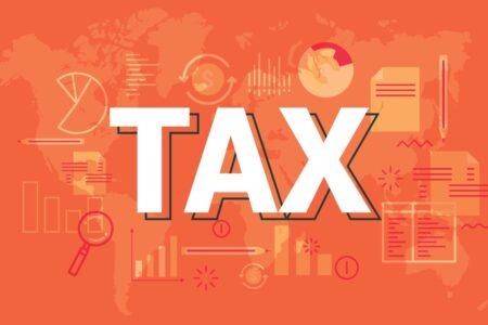 corporation tax rate rise implications - TAX in white in the middle with an orange background with pens, paper and other related equipment