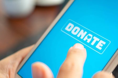 Photo of person using mobile phone to donate to charity